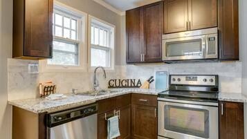 A kitchen with dark wood cabinets, stainless steel appliances, a built-in microwave, and a dishwasher.