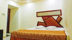 Een hotelkamer met een bed, hoofdeinde en een deur.