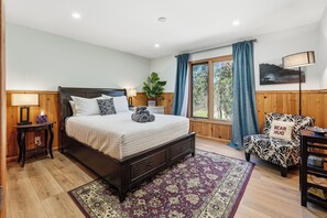 A bedroom with a bed, bedside tables, a chair, a lamp, and a window with curtains. - Wildflower Ridge, Near Yosemite & Bass Lake (Oakhurst)