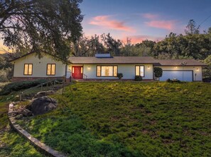 A two-story house with a red door, a garage, and a well-maintained lawn. - Wildflower Ridge, Near Yosemite & Bass Lake (Oakhurst)