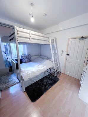 1 dormitorio, tabla de planchar con plancha, ropa de cama