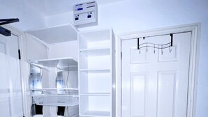 A white interior with a door, a trash bin, and a wall-mounted electrical box. - Entire London center studio flat Victorian build/quiet/mins tube river/1 shower (London)