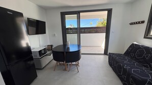 A compact living space with a kitchenette, a dining area, and a sofa. - T2 any comfort Tranquillity assured has only 5 min of st stone (Saint-Pierre)