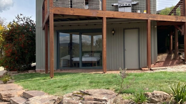 Ein modernes, zweistöckiges Haus mit Balkon, Garage und gepflegtem Rasen.