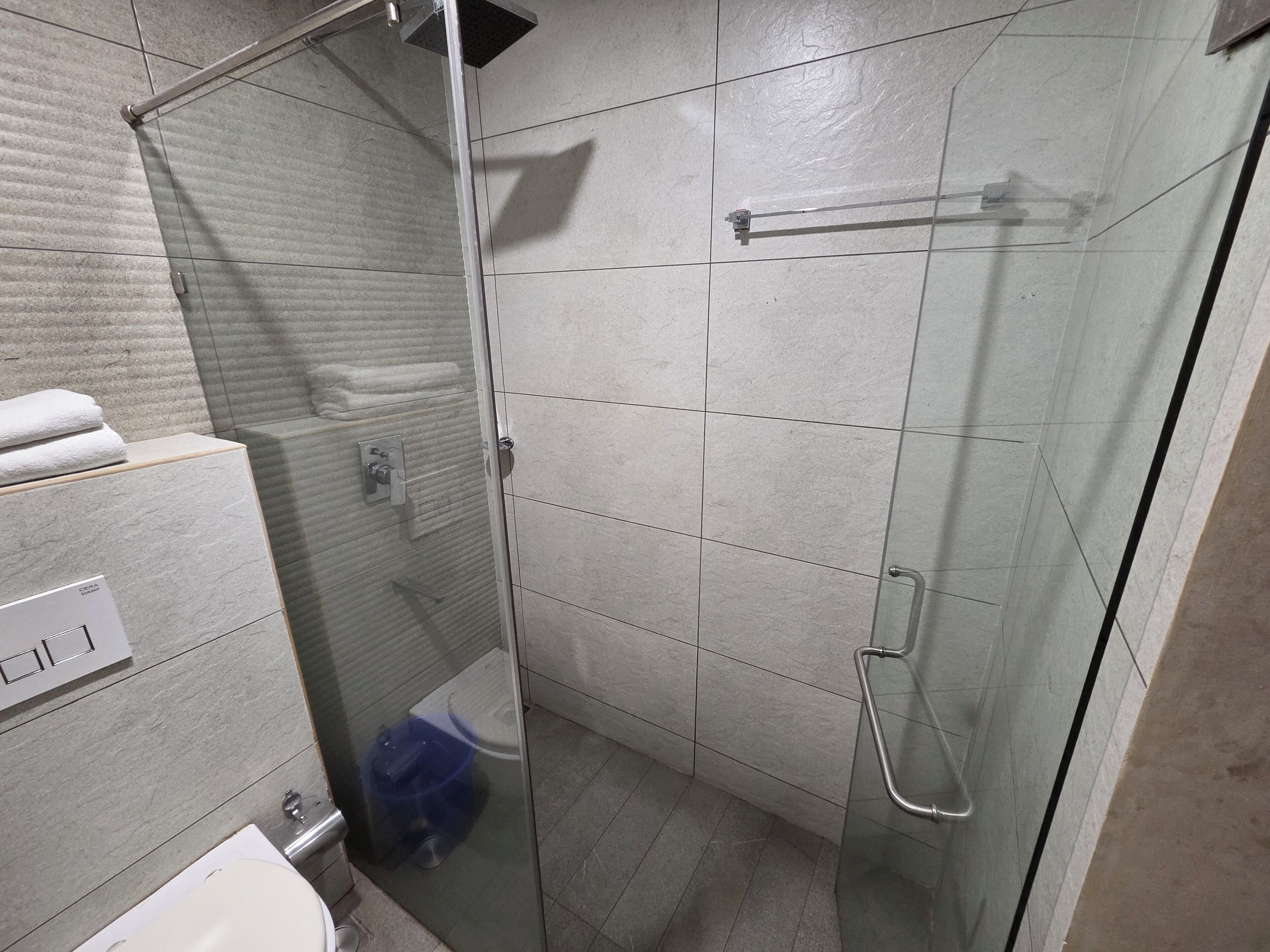 Une salle de bain avec une douche à parois en verre, des toilettes et un lavabo.