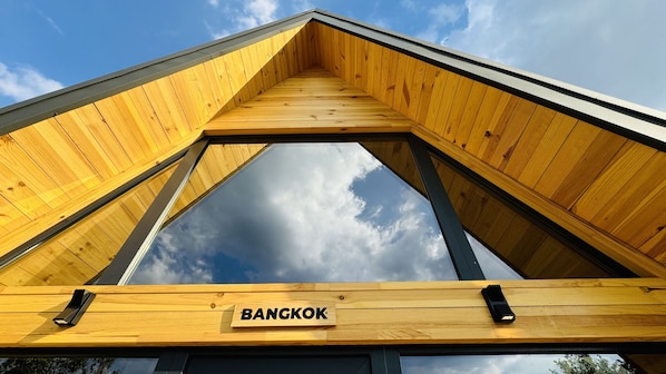 A wooden structure with a triangular roof and a sign that reads 'BANGKOK.'