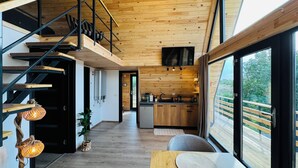 Un intérieur moderne avec un escalier en bois, un coin cuisine et un espace salon offrant une vue agréable.