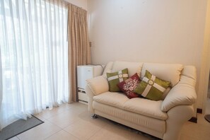 Deluxe suite, uitzicht op zwembad | Woonruimte