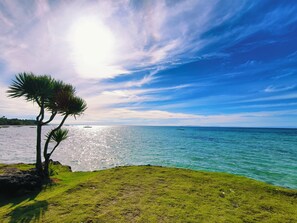 A coastal landscape with a grassy area and a body of water. - Ogtong Cave Resort (Santa Fe)