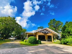 A building with a sign reading 'CATHY'S BEACH CLUB' and 'OCTONG COVE' with a clear blue sky and lush greenery around. - Ogtong Cave Resort (Santa Fe)
