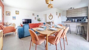 A modern living room with a sofa, dining table, chairs, and a kitchen area with cabinets and a countertop. - Nice house in the hills, with private jacuzzi, sunny terrace! (Nice)