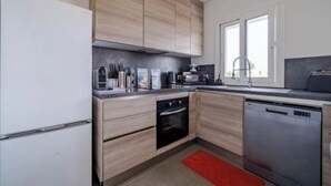 A modern kitchen with wooden cabinets, a built-in oven, a dishwasher, and a red rug. - Nice house in the hills, with private jacuzzi, sunny terrace! (Nice)