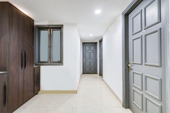 A hallway with a wooden wardrobe, a window, and a door.