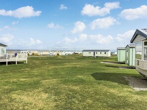 A caravan park with multiple caravans, grassy areas, and a clear sky.