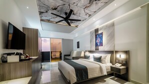 A modern hotel room with a large bed, a flat-screen TV, a desk, and a ceiling fan. - Samann Blue (Hulhumale)