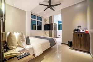 Una habitación de hotel con una cama, televisión, un armario de madera y un teléfono.