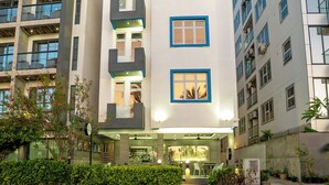 A multi-story hotel with balconies, a ground entrance, and a well-lit facade. - Samann Blue (Hulhumale)