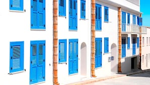 A white building with blue shutters and columns. - Cala Del Porto 2-room-apartment 3P (Marettimo)