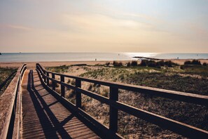 A wooden boardwalk leading to a beach with dunes and a clear view of the sea. - Cala Del Porto 2-room-apartment 3P (Marettimo)