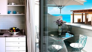 A balcony with a glass table, chairs, and a vase of flowers. - Cala Del Porto 2-room-apartment 3P (Marettimo)