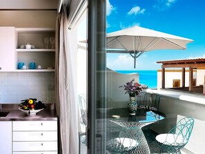 A balcony with a glass table, chairs, and a vase of flowers. - Cala Del Porto 2-room-apartment 3P (Marettimo)