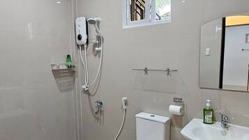 Een moderne badkamer met toilet, hygiëneschuimer, douche en wastafel.
