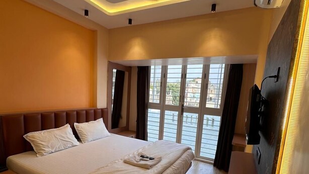 Ein modernes Schlafzimmer mit einem großen Bett, Deckenventilator und großen Fenstern.