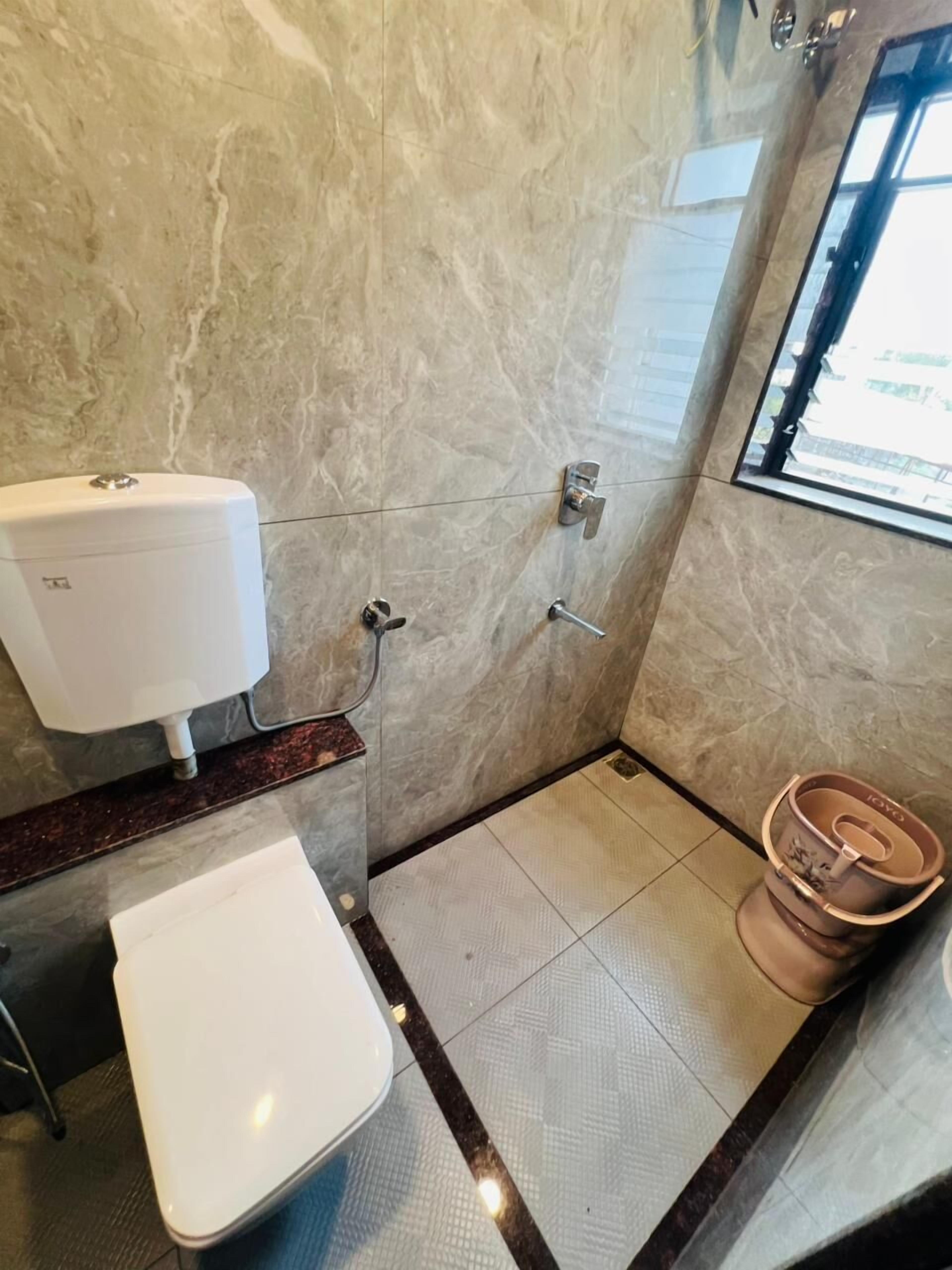 A bathroom with a toilet, bidet, and shower.