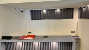 Ein Empfangsschalter mit modernem Design, eine Überwachungskamera und ein Fenster darüber.