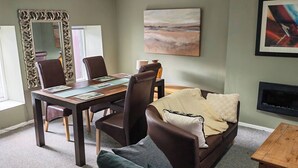 Una sala de estar moderna con comedor, un sofá, una mesa de centro y una chimenea.