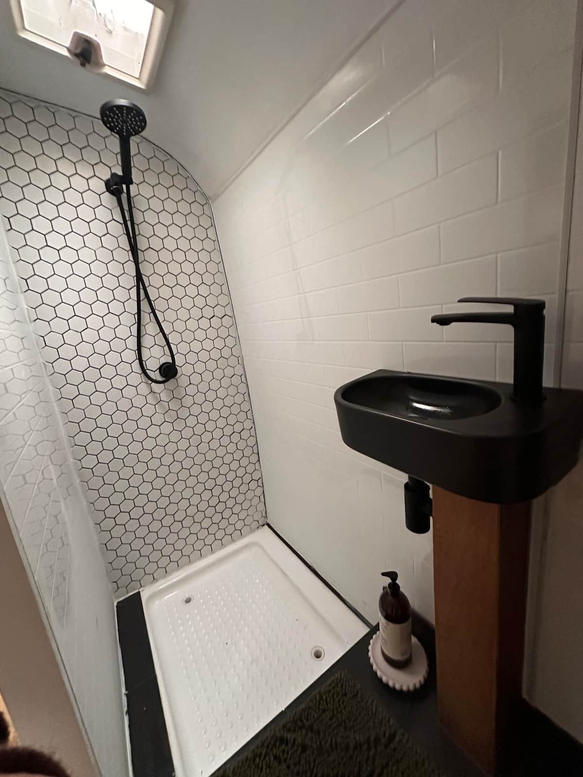 Ein Badezimmer mit Dusche, Waschbecken und Toilette.