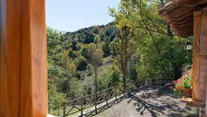 Ein Holzbalkon mit Blick auf eine hügelige Landschaft.