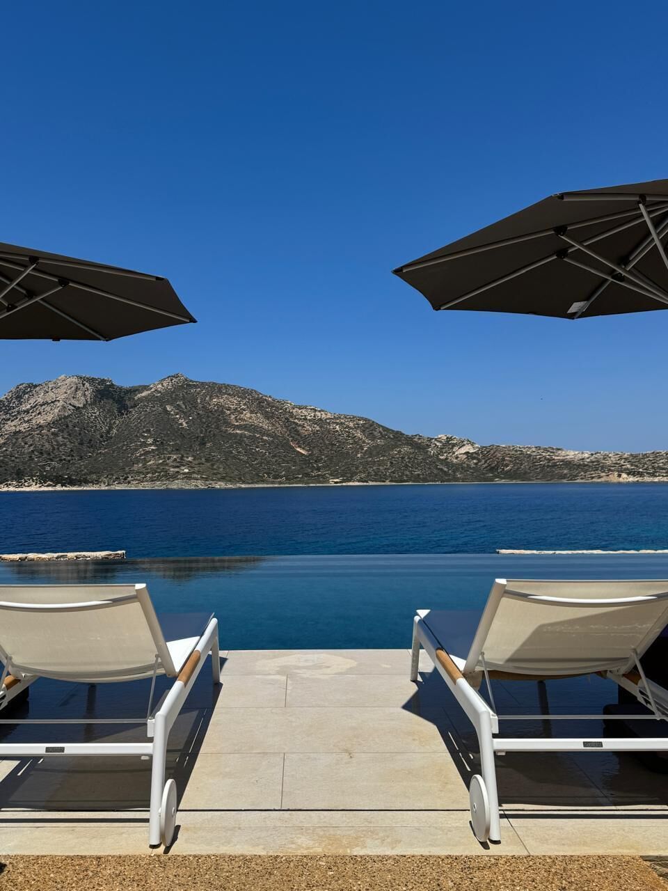 Una piscina al aire libre de temporada, sombrillas