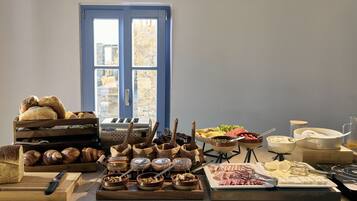 A breakfast buffet with various food items and utensils.