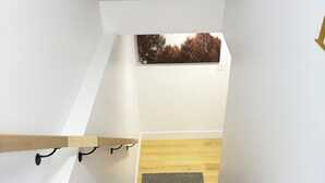 A staircase with wooden steps and a black carpet at the bottom. - Luxury 1 BedRoom Suite | New | Quite | Private| Near Amenities.  (Moncton)