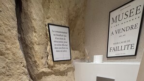 Une salle de bain avec un mur en pierre, des toilettes blanches et des carreaux de sol à motifs.