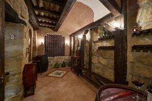 A stone-walled interior with wooden beams, a barrel, and a wine glass. - Historichaven by Fidalsa (Labastida)
