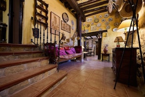 A rustic interior with stone steps, a wooden bench with colorful cushions, and a wall decorated with plates. - Historichaven by Fidalsa (Labastida)