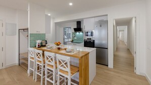 A modern kitchen with a central island, white cabinetry, and stainless steel appliances. - City and Beach by Fidalsa (Alicante)