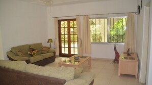 A living room with a sofa, a coffee table, and a small side table. - Vokundahouse Gambia: Your private home away from home (Serekunda)