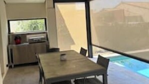 En modern inredning med ett matbord, stolar, en tv och ett köksområde.