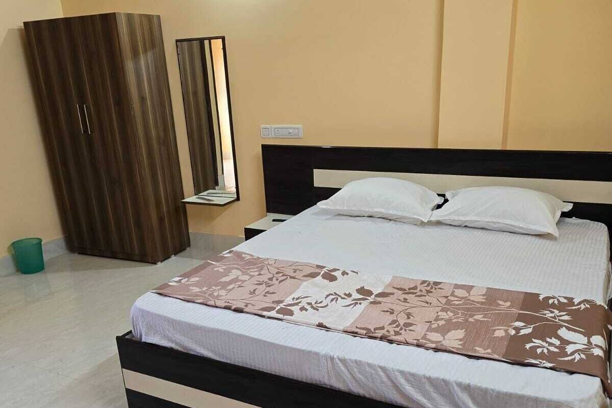Un dormitorio con cama, armario y espejo.