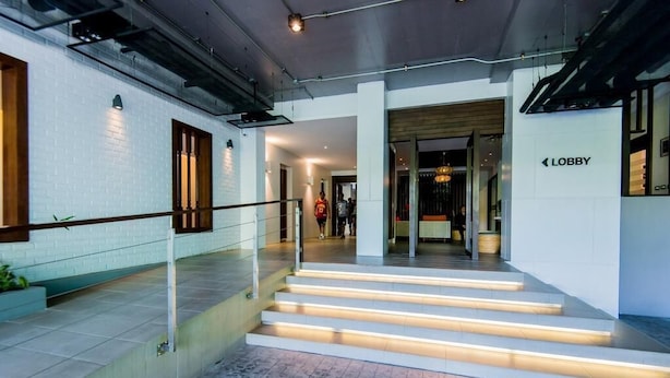 A modern lobby with a staircase, a sign indicating the lobby area, and a visible entrance to another section. - Quiet condo with pool vibe (Tambon Patong)