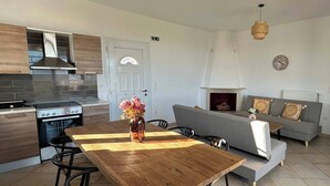 Een moderne keuken met een fornuis, oven en een houten eettafel met stoelen.