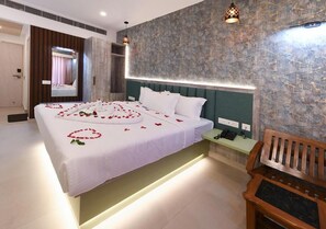 Una habitación de hotel con cama, mesita de noche y un banco.