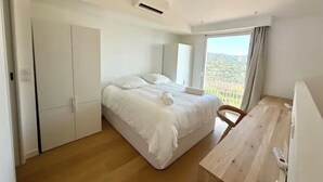 A bedroom with a bed, a desk, and a wardrobe. - Charmant Mazet, Vue Mer, Piscine/Sea View Mazet with Private Garden & Pool Quiet (Roquebrune-sur-Argens)