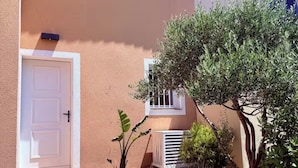 A building with a tiled roof, a white door, and a small window. - Charmant Mazet, Vue Mer, Piscine/Sea View Mazet with Private Garden & Pool Quiet (Roquebrune-sur-Argens)