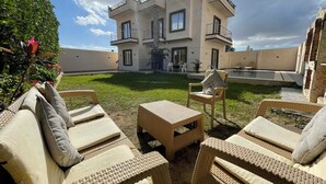 A modern two-story house with a swimming pool, outdoor seating, and a well-maintained lawn. - La Dolce Villa with Private Pool (Alexandria Governorate)
