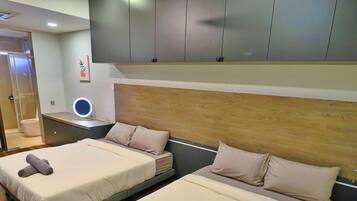 Een moderne hotelkamer met twee bedden, een nachtkastje met lamp, een spiegel en een houten hoofdbord.