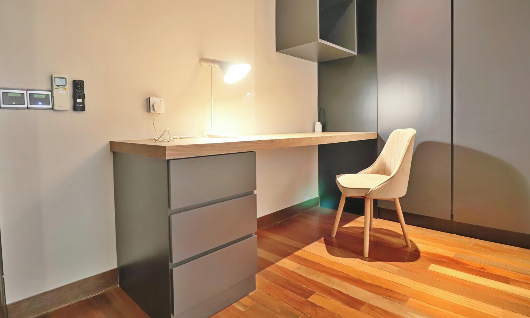 A modern room with a desk, chair, and built-in storage.